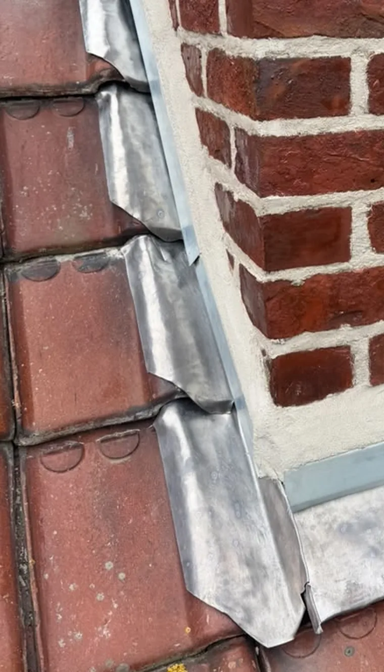 Solin en zinc posé autour d'une souche de cheminée sur une toiture en tuiles, métropole lilloise